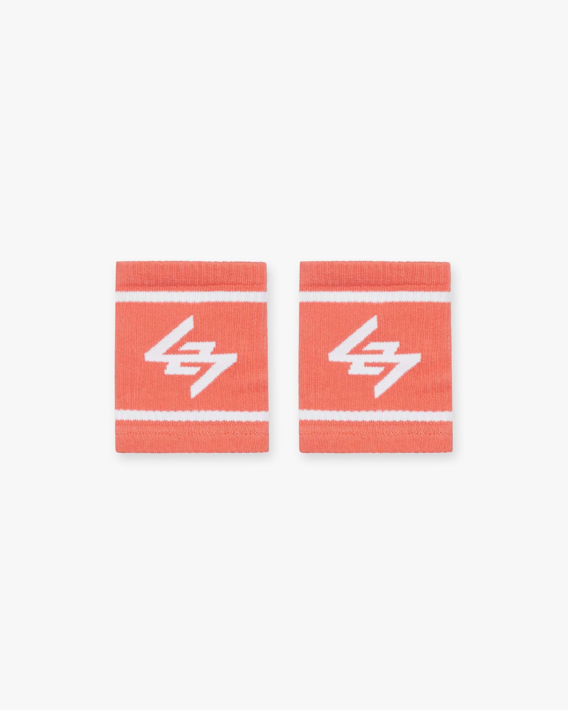 Front product image of mens coral wrist bands on a plain white background | 247 Logo Wrist Bands in Coral | Stretchy accessory bands | 247 Accessories | Represent Clo