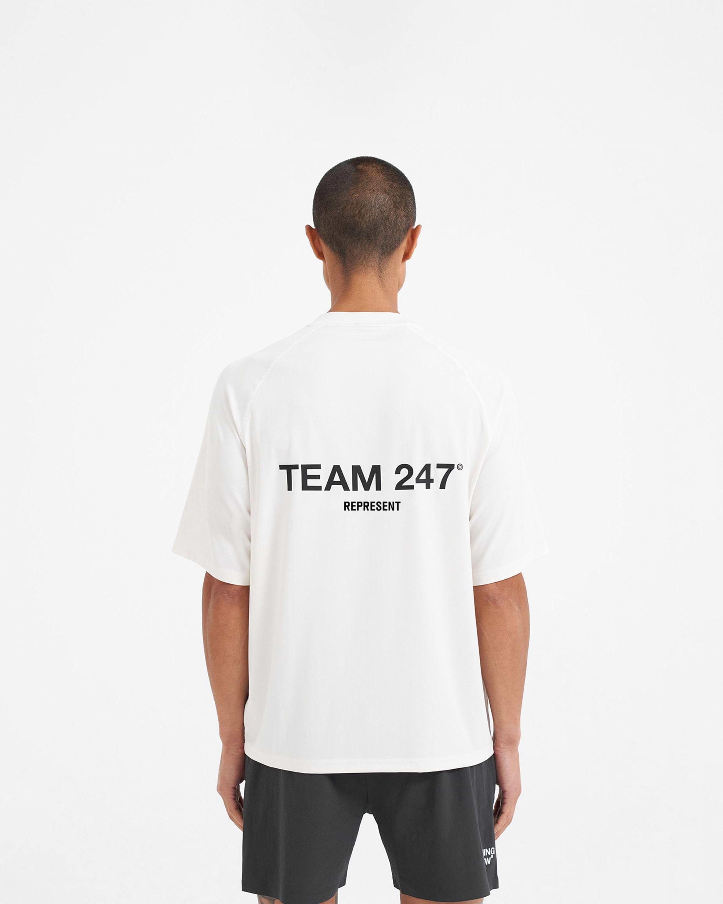Man wearing a white oversized t-shirt on a plain white background | Team 247 Oversized T-Shirt in Flat White | Lightweight breathable quick-dry gym top | 247 T-Shirts | Represent Clo