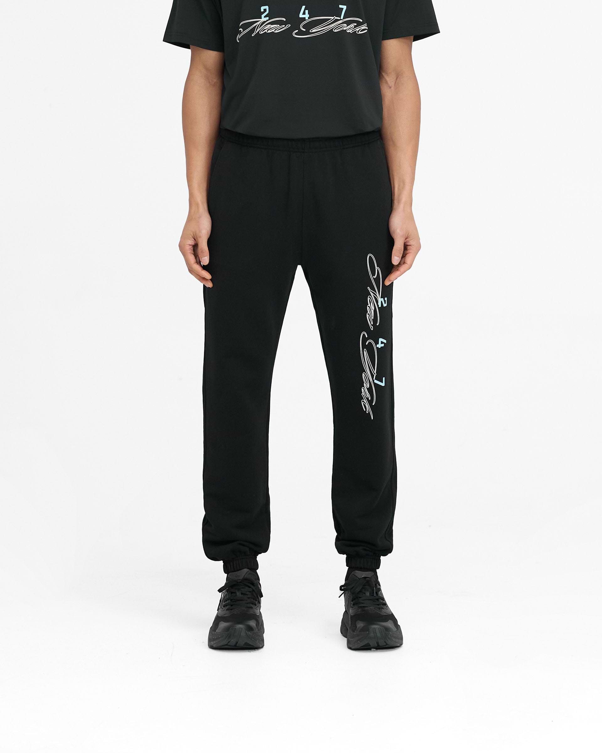 Man wearing black joggers on a plain white background | 247 New York Sweatpant in Black | Joggers with elasticated waistband and cuffs | 247 Pants | Represent Clo