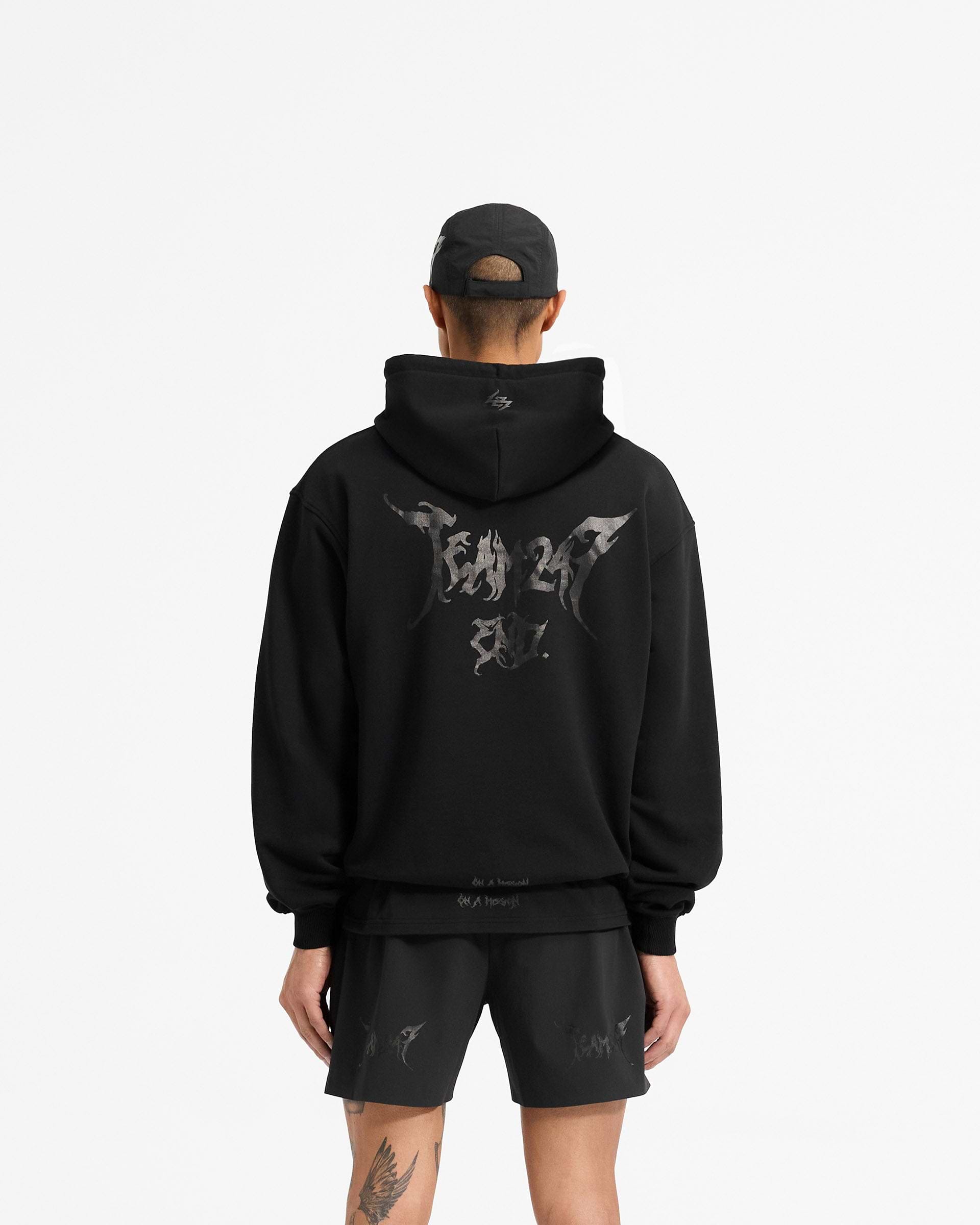 Man wearing a black hoodie on a plain white background | Team 247 X END Oversized Hoodie in Jet Black | Oversized fit hoodie with co-branded graphics | 247 Hoodies | Represent Clo