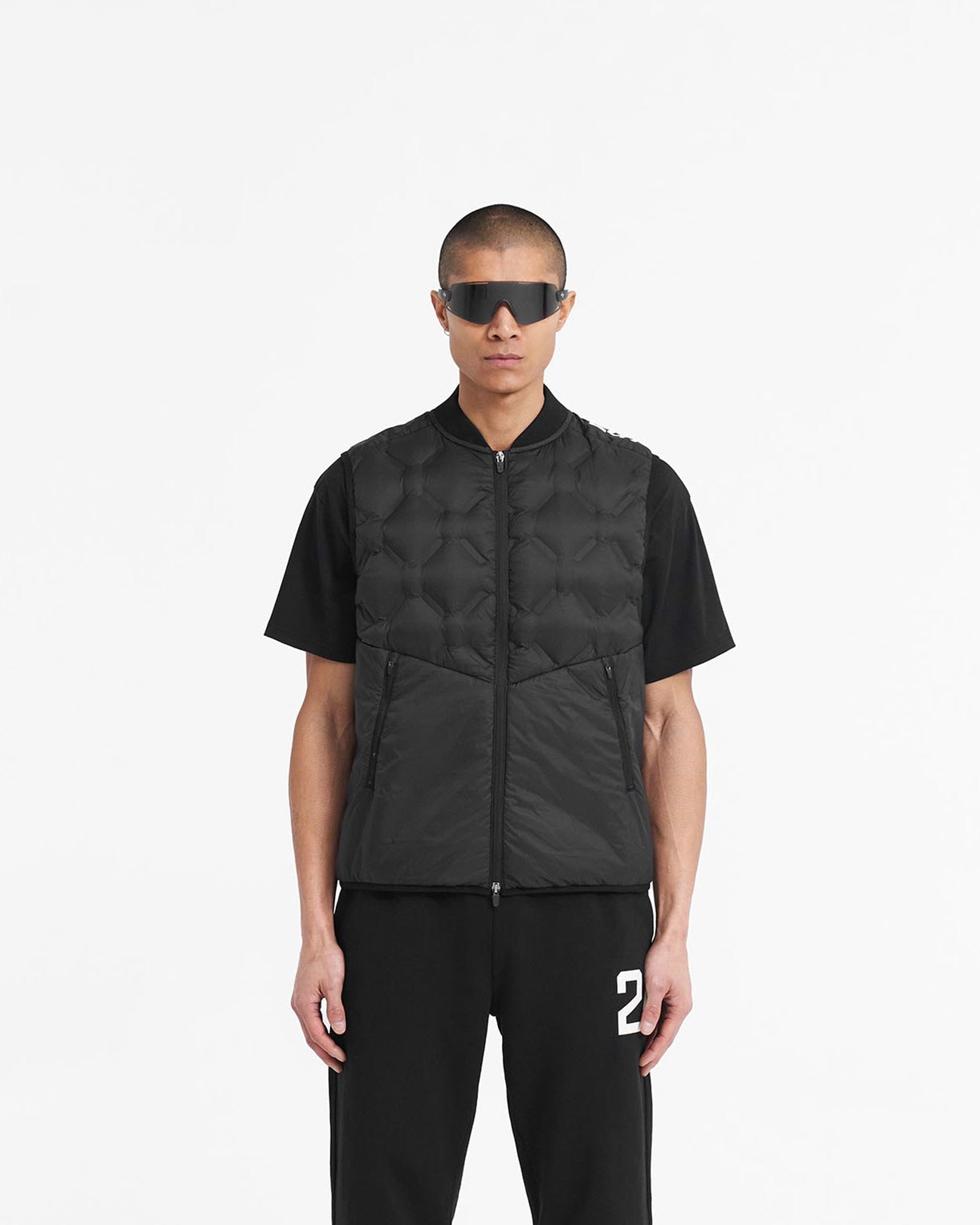 Man wearing a black lightweight gilet on a plain white background | 247 Lightweight Gilet in Black | Gilet with bomber collar and zip pockets | 247 Outerwear | Represent Clo