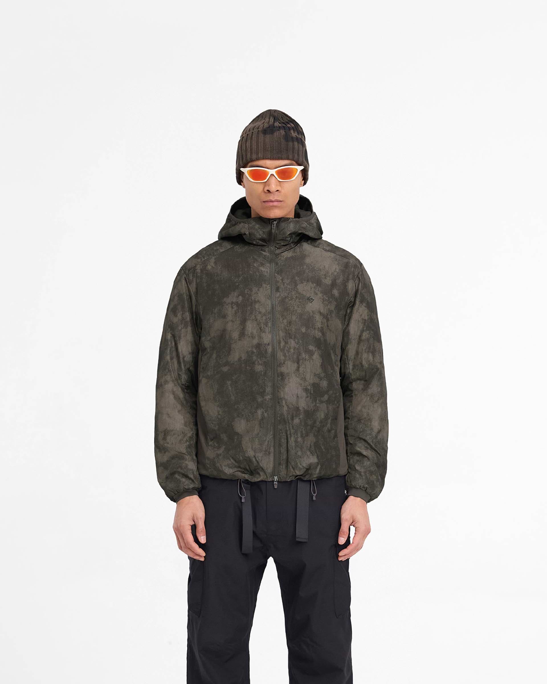 Man wearing a brown insulated jacket on a plain white background | Team 247 Insulated Jacket in Terrain | Insulated jacket with adjustable hood and gridded fleece panels | 247 Outerwear | Represent Clo