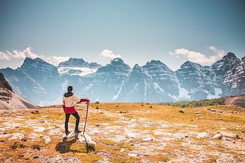 A man standing on top of a mountain, looking at other mountains