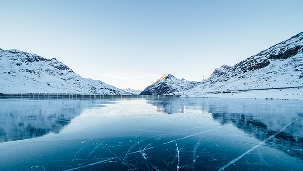 Heat Holders® thermal base layers | Frozen river with snow laden banks and mountains in the distance