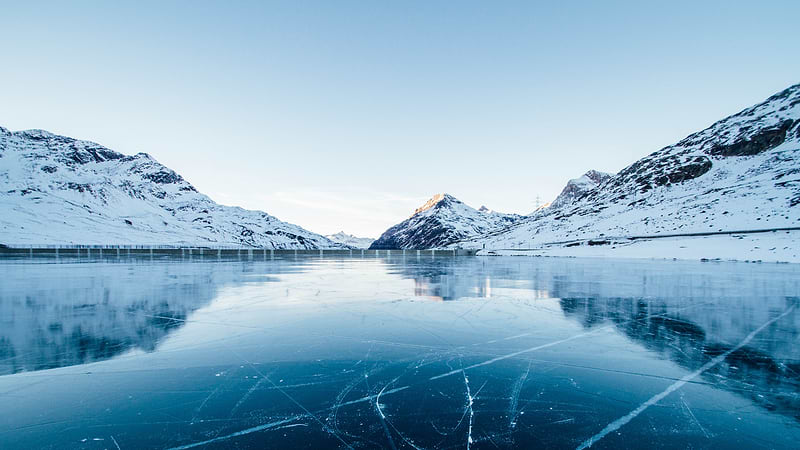 Heat Holders® thermal base layers | Frozen river with snow laden banks and mountains in the distance