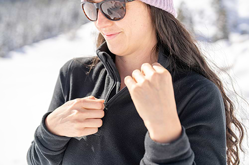 Woman skier wearing Heat Holders® thermal hat and zip jacket.  out in the snow.