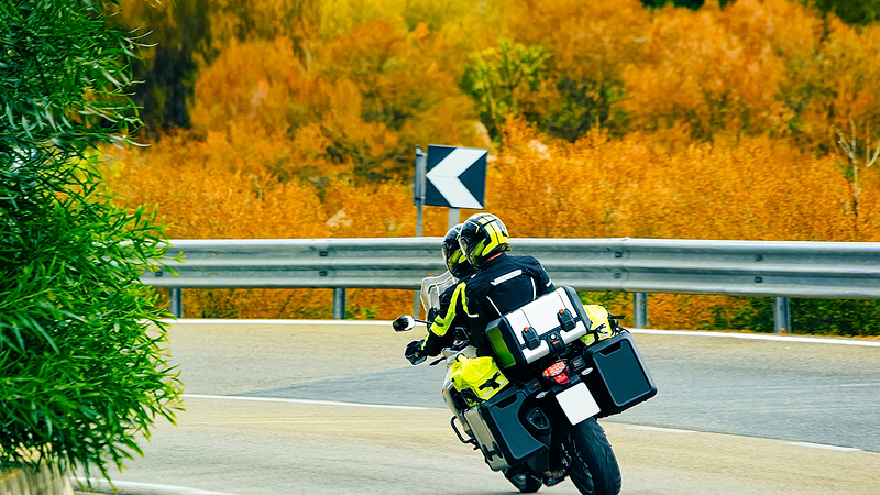 Two people on a motorcycle in fall