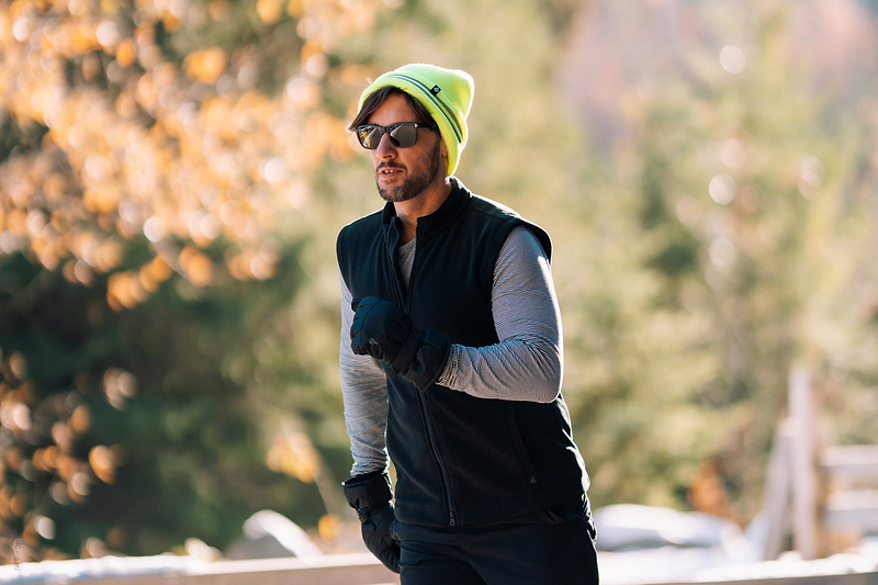 Man running in the cold wearing Heat Holders® vest, hat, base layers, and gloves