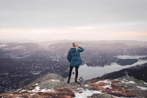 Woman overlooks city while on a winter hike. Heat Holders® Thermal Clothes