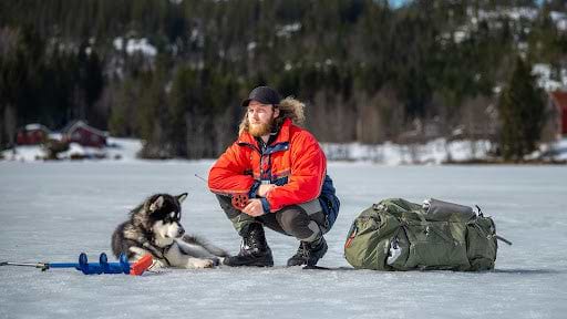 Man and dog rest while on a winter hike. | Heat Holders® thermal socks