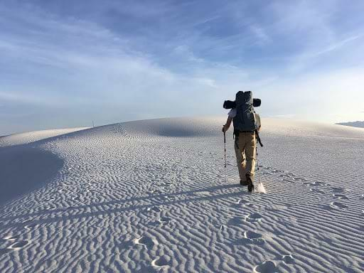 Person hiking up a snowy hill. |Heat Holders® Thermal Hats