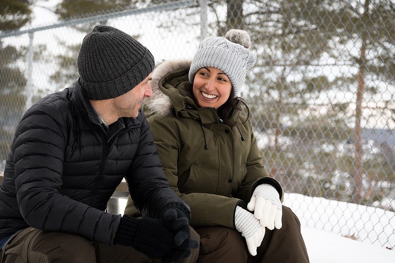 Woman and man rest while on a winter hike. | Heat Holders®