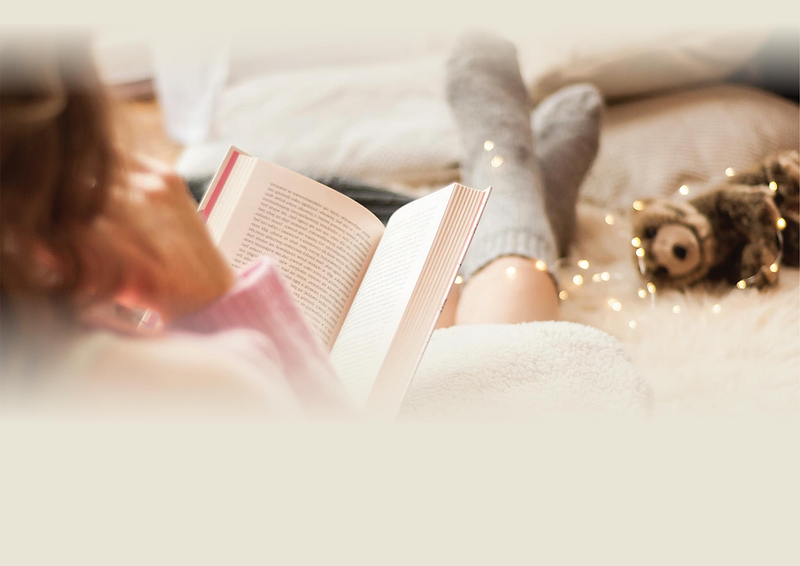 Woman wears Heat Holders® slipper socks while reading