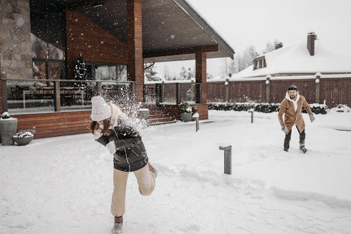 Couple has a snowball fight out in the snow. | Heat Holders® Thermal Base layers | thermal underwear