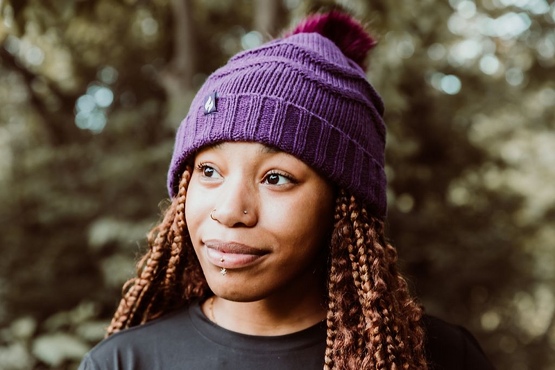 Woman wearing a Heat Holders® knitted thermal hat with pompom