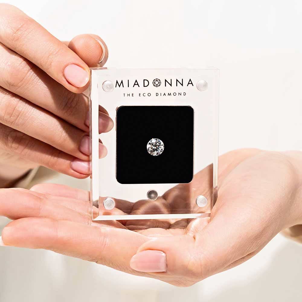 MiaDonna lab-grown diamond in a hand-held transparent display box.