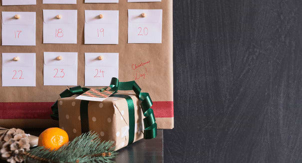 Paper wrapped Christmas calendar and gift with green bow.