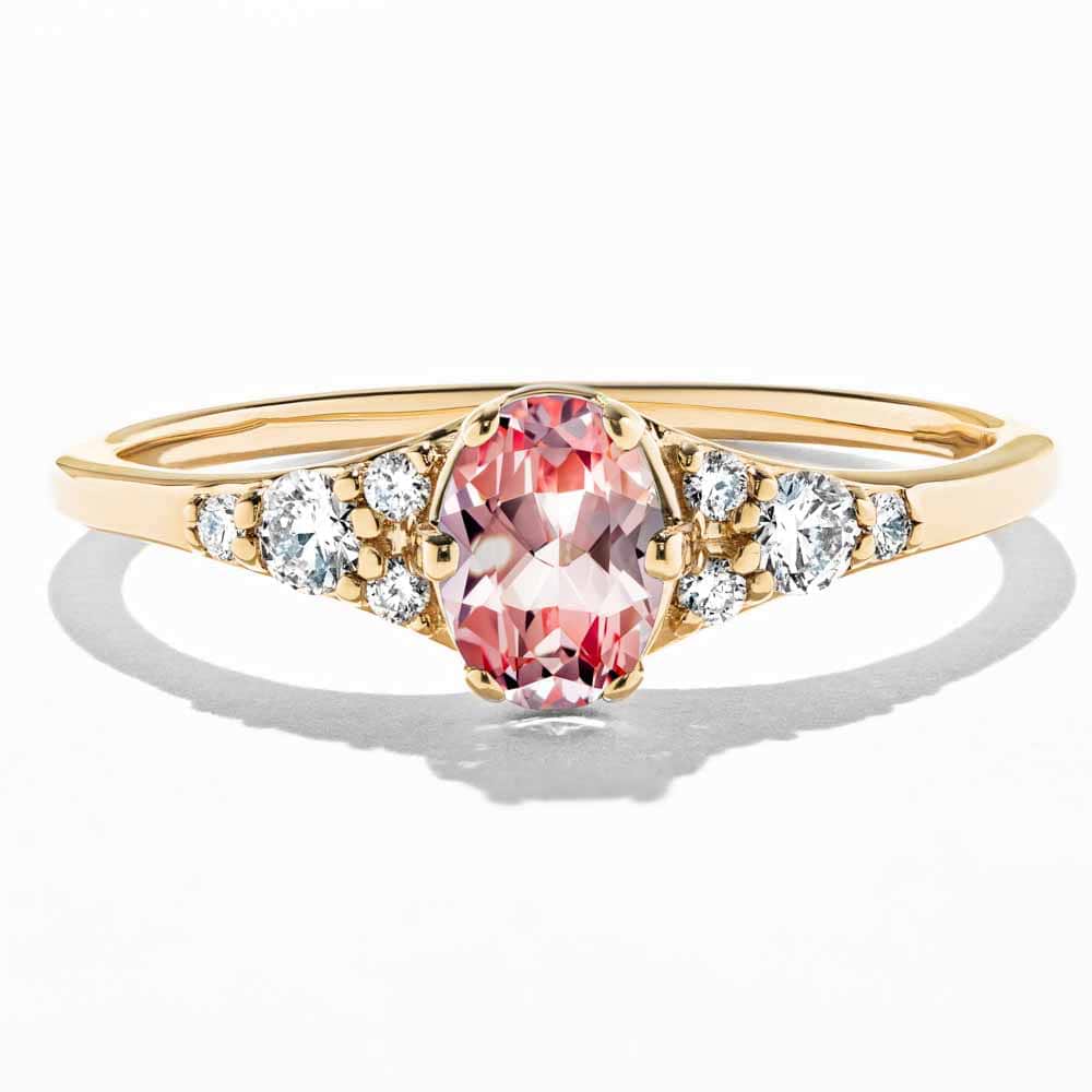 Shown here in 14K Yellow Gold with an Oval Cut Lab Grown Pink Champagne Sapphire|diamond accented engagement ring with a lab grown gemstone center stone with accenting lab grown diamonds by MiaDonna