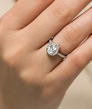 halo accented diamond ring with a pear cut lab grown diamond center stone