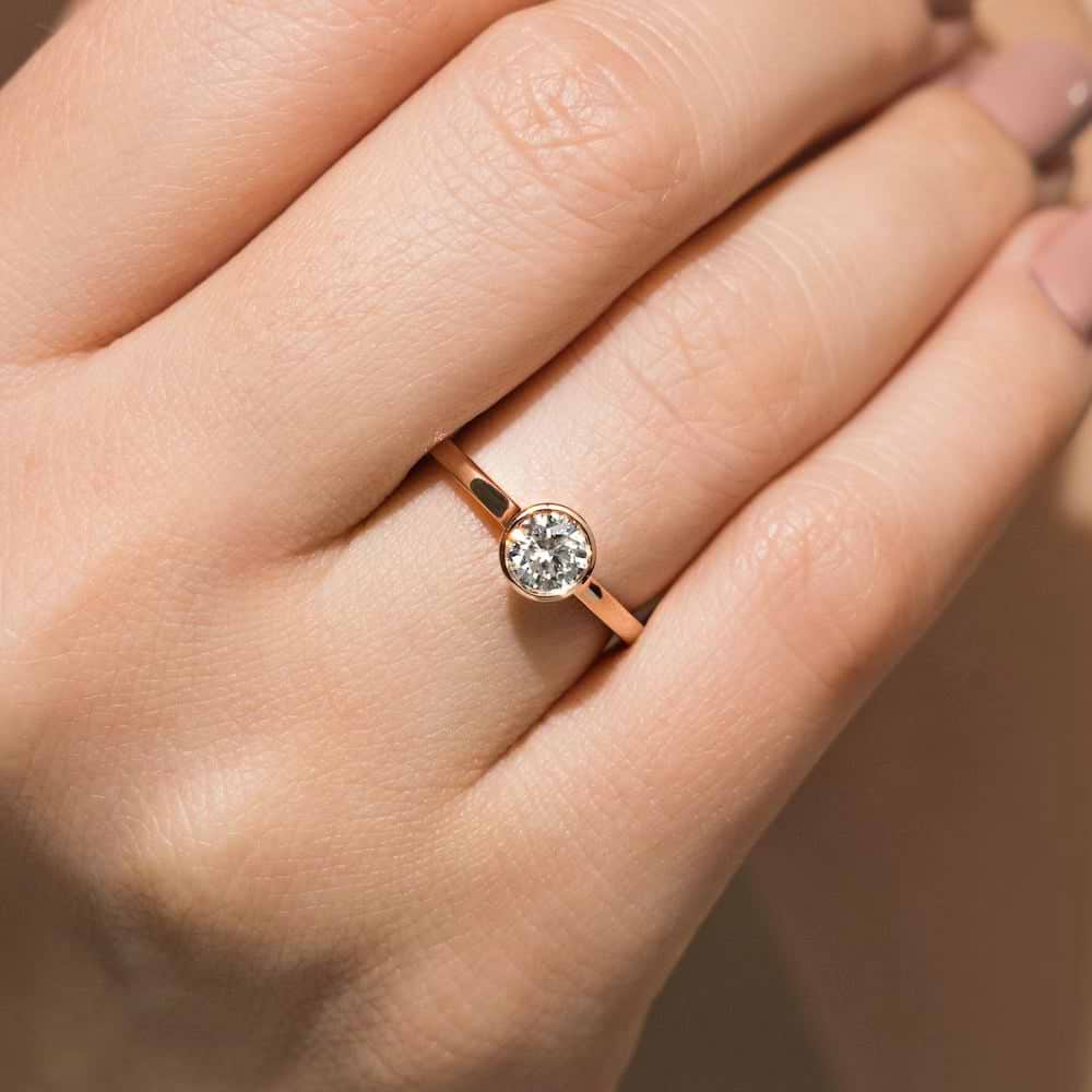 Shown In 14K Rose Gold With An Oval Cut Center Stone|bezel solitaire ring with an oval cut lab grown diamond center stone