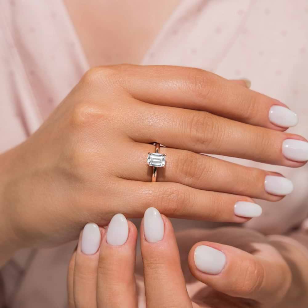Shown In 14K Yellow Gold with an Emerald Cut Center Stone|traditional claw prong solitaire ring with an emerald cut lab grown diamond center stone