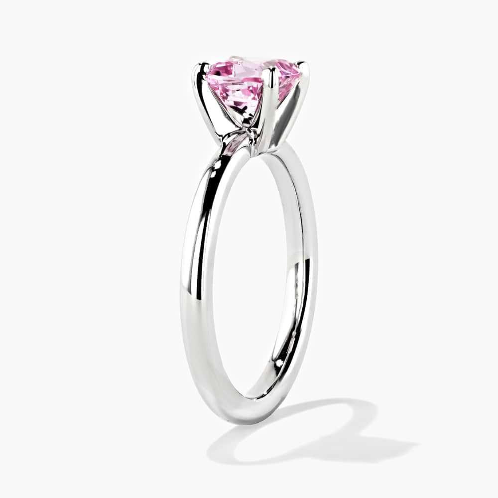 Shown in 14K White Gold|traditional solitaire engagement ring with a cushion cut lab grown pink champagne sapphire gemstone center stone set in 14k white gold recycled metal