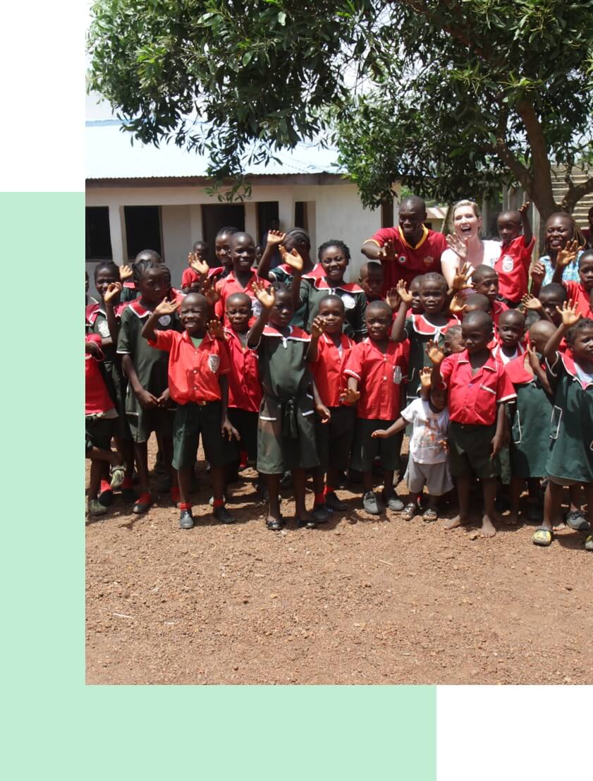 MiaDonna CEO Anna-Mieke Anderson smiles and waves with a large group of children at the Elwou Orphange, a The Greener Diamond supported project in Liberia. 