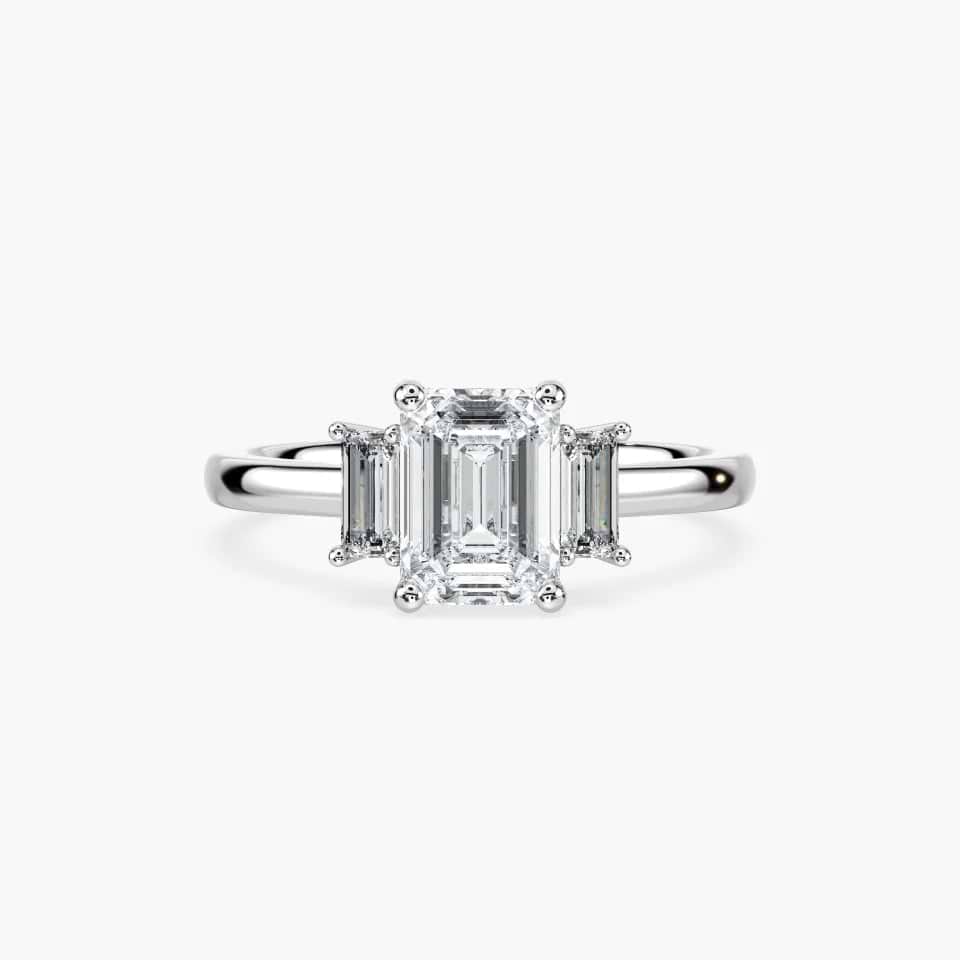 Shown in 18K White Gold|3 stone engagement ring shown in white gold with a lab grown diamond emerald cut center stone