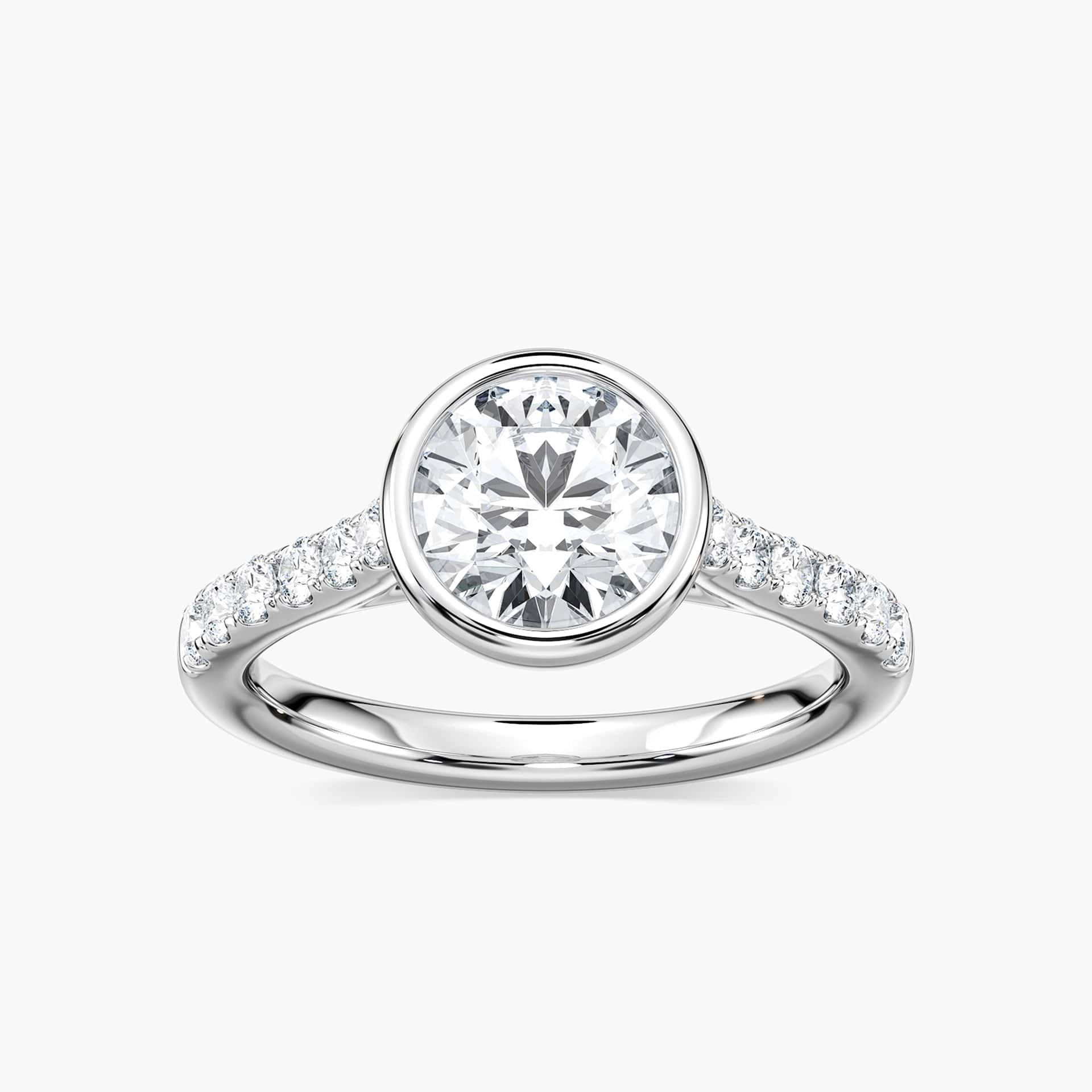 Shown with a bezel set 1.0ct Round cut Lab-Grown Diamond with accenting stones on the band in recycled 14K white gold | stackable engagement ring Shown with a bezel set 1.0ct Round cut Lab-Grown Diamond with accenting stones on the band in recycled 14K white gold