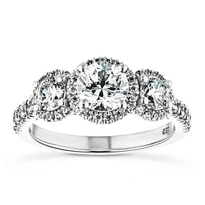 Luxurious three stone engagement ring with round cut lab grown diamonds surrounded by diamond halos in 14k white gold