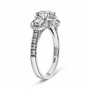 Luxurious three stone engagement ring with round cut lab grown diamonds surrounded by diamond halos in 14k white gold shown from side