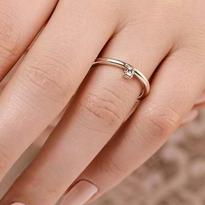 Unique asymmetrical stackable ring with 0.10ct round cut lab grown diamond in 14k white gold shown worn on hand
