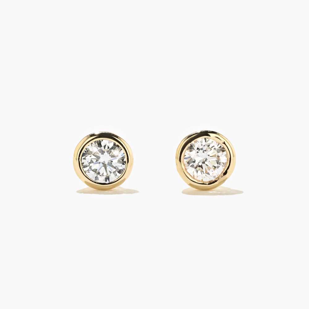 Shown here with 0.50ctw Round lab-grown diamonds in recycled 14K yellow gold. | Lab-grown diamond yellow gold bezel stud earrings.
