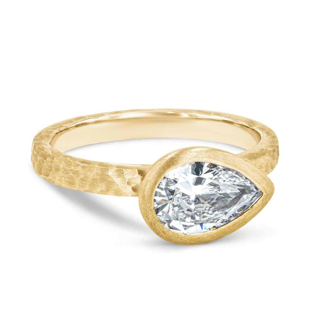 Shown in 14K Yellow Gold with a Satin Hammer Finish|bezel set satin hammer finish engagement ring with pear cut east to west lab grown diamonds