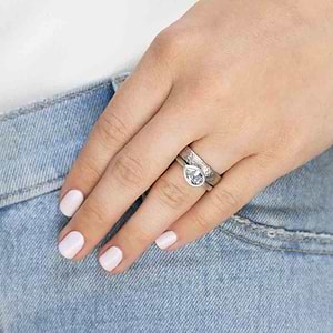 plain metal band with satin hammer finish in 14k white gold stacked with bezel set east to west solitaire engagement ring