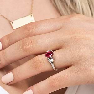Gorgeous three stone engagement ring with 1ct oval cut lab grown ruby and half moon cut diamond side stones in 14k white gold worn on hand