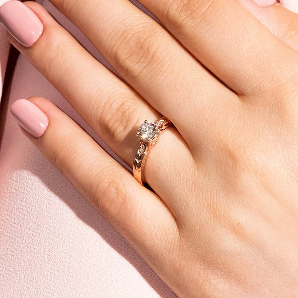 Shown with 1ct Round Cut Lab Grown Diamond in 14k White & Rose Gold|Antique nature inspired engagement ring with floral designed head holding a 1ct round cut lab grown diamond in 14k rose gold worn on hand