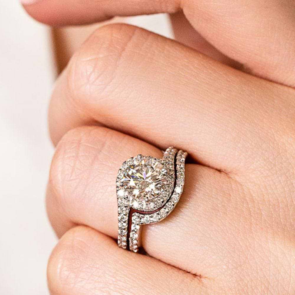 Shown with a 1.0ct Round cut Lab-Grown Diamond with recycled accenting diamond halo and band in recycled 14K white gold with matching band 