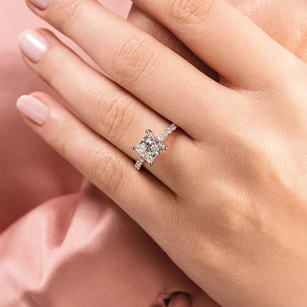 Shown with 1ct Cushion Cut Lab Grown Diamond in Platinum|Diamond accented engagement ring with 1ct cushion cut lab grown diamond set in a four prong trellis in platinum shown worn on hand