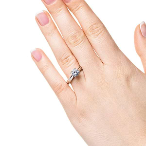 Simple solitaire engagement ring with cathedral design holding a 1ct round cut lab grown diamond in 14k white gold shown worn on hand