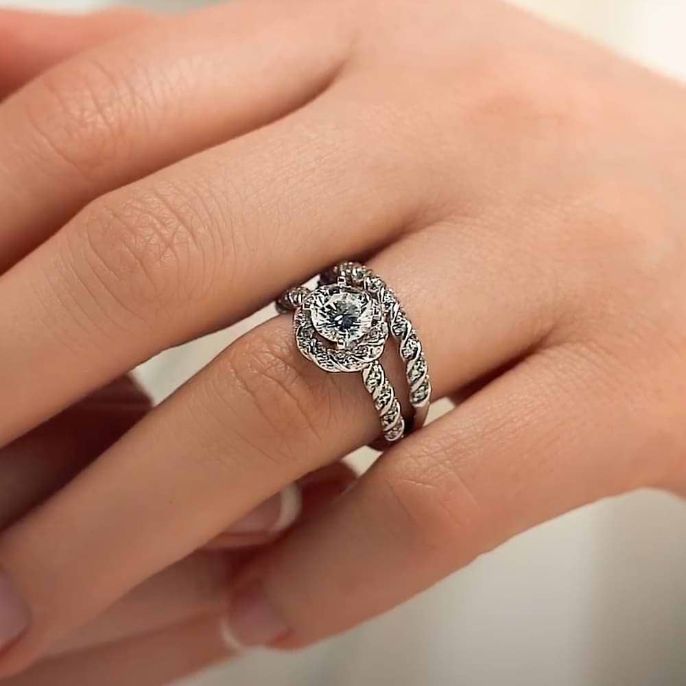 Shown with a 1.0ct Round cut Lab-Grown Diamond with diamond entwined halo and band in recycled 14K white gold with matching wedding band