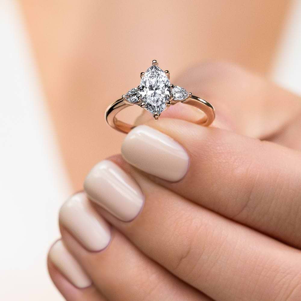 Shown In 14K Rose Gold With A Marquise Cut Center Stone|three stone ring with accenting pear cut stone and a marquise cut lab grown diamond center stone
