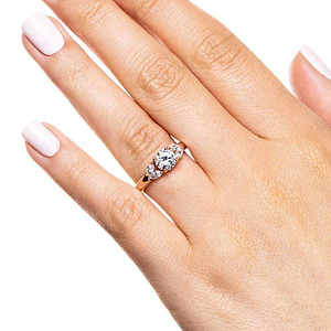Diamond accented engagement ring with 0.75ct round cut lab grown diamond center and 4 marquise cut side stones in 14k rose gold shown worn on hand