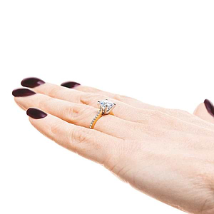 Diamond accented engagement ring with 1.5ct round cut lab grown diamond set in 6 prong 14k yellow gold setting worn on hand sideview