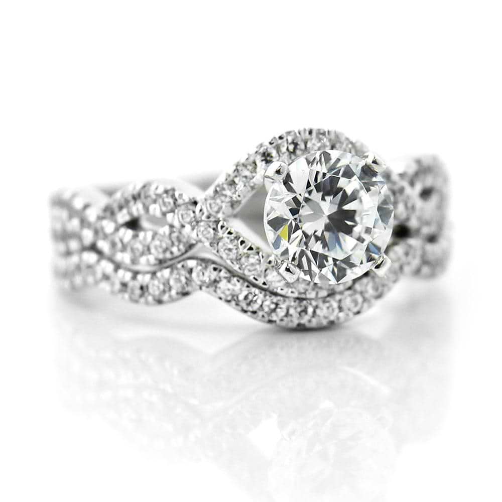 Shown with a 1.0ct Round cut Lab-Grown Diamond with infinity style diamond accented band with matching wedding band 