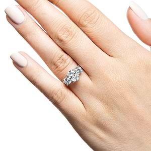 Three stone trellis set lab grown diamond engagement ring in white gold worn on hand