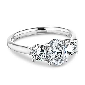 Romantic three stone engagement ring with 1ct oval cut lab grown diamond and two 0.5ct round cut lab diamond side stones in 14k white gold