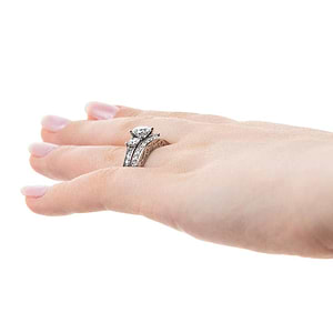  three stone engagement ring Shown with round cut center stone and two Princess cut Lab-Grown Diamonds with scroll detailing and accenting diamonds on the band in recycled 14K white gold with matching wedding band