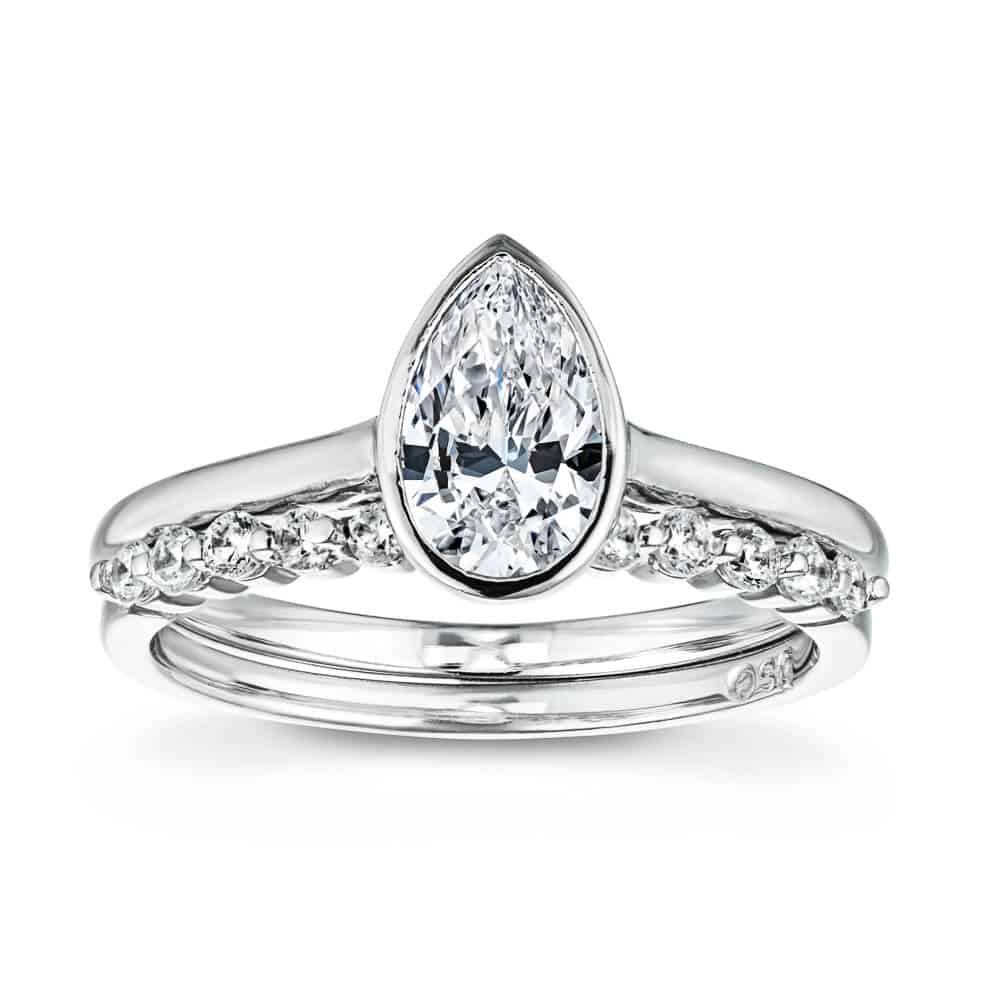 Shown with a bezel set 1.0ct Pear cut Lab-Grown Diamond in recycled 14K white gold with the matching diamond accented band, can be purchased as a set for a discounted price 