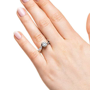 Modern two tone engagement ring with diamond accented split shank and half bezel set 1ct round cut lab grown diamond in 14k white gold worn on hand